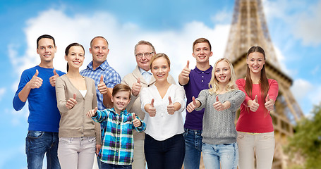 Image showing smiling people showing thumbs up over eiffel tower