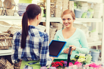 Image showing happy women with tablet pc at flower shop