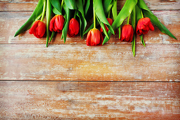 Image showing close up of red tulips on wooden background