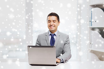 Image showing happy businessman working with laptop in office