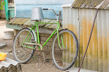 Image showing Old bicycle with a bucket on the saddle