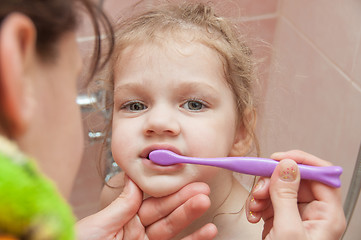 Image showing Mom helping girl brushing teeth