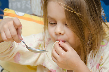 Image showing Funny five year old girl eating spaghetti sitting in the crib