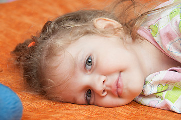 Image showing Portrait of cheerful three-year girl lying on the couch