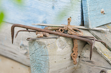 Image showing Pile of old tools and pieces of iron lying on the wooden frame of the old house