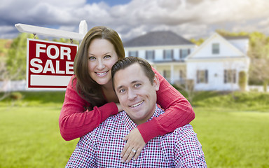 Image showing Happy Couple In Front of For Sale Sign and House