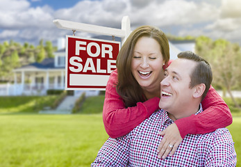 Image showing Happy Couple In Front of For Sale Sign and House
