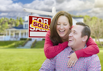 Image showing Couple In Front of Sold For Sale Sign and House