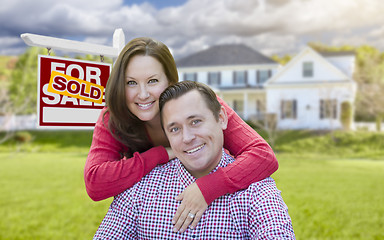 Image showing Couple In Front of Sold For Sale Sign and House