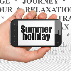 Image showing Tourism concept: Hand Holding Smartphone with Summer Holiday on display