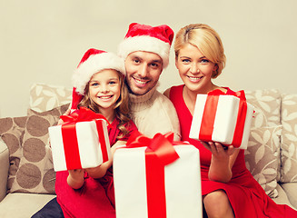 Image showing smiling family giving many gift boxes