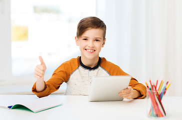 Image showing happy boy with tablet pc showing thumbs up at home