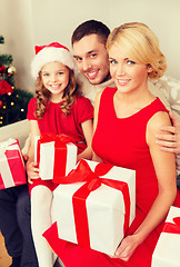 Image showing smiling family holding many gift boxes