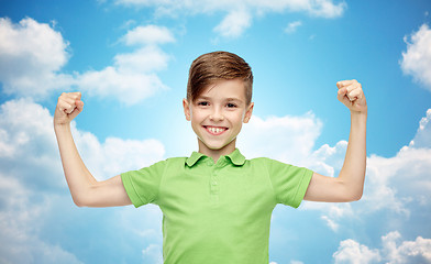 Image showing happy boy in polo t-shirt showing strong fists