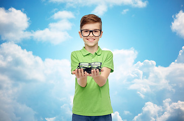 Image showing happy boy in green polo t-shirt holding eyeglasses