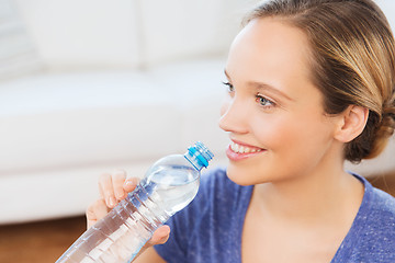 Image showing happy woman with water bottle at home