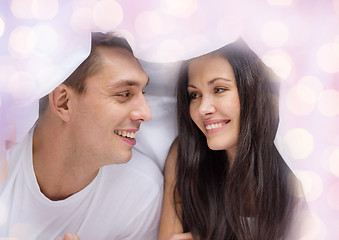 Image showing happy couple under blanket in bed