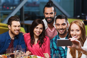 Image showing friends taking selfie by smartphone at restaurant