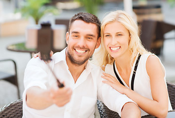 Image showing happy couple taking selfie with smartphone at cafe