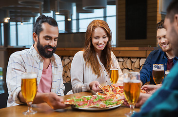 Image showing friends eating pizza with beer at restaurant