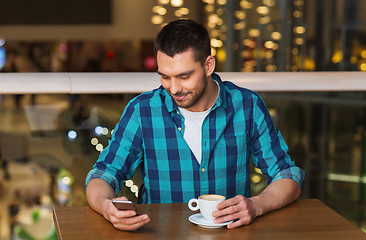 Image showing happy man with smartphone and coffee at restaurant