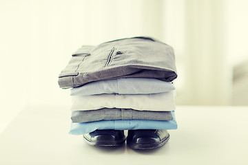 Image showing close up of male shirts, pants and shoes on table