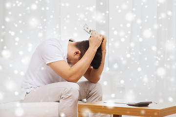 Image showing man with money and calculator at home