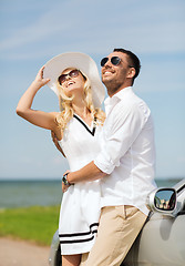 Image showing happy man and woman hugging near car at sea