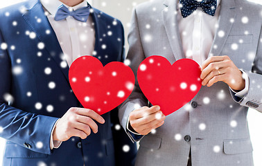 Image showing close up of male gay couple holding red hearts