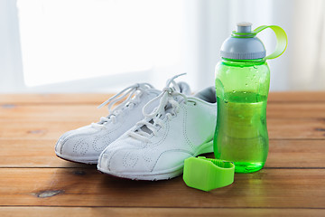 Image showing close up of sneakers, bracelet and water bottle