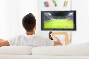 Image showing man watching football game on tv at home from back