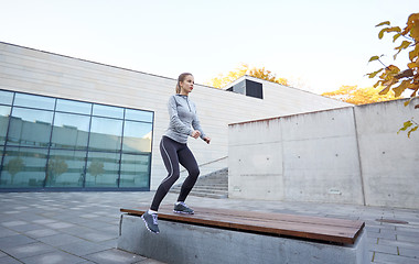 Image showing woman exercising on bench outdoors