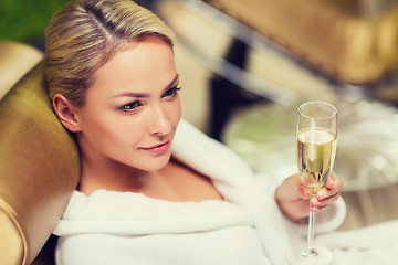 Image showing beautiful young woman drinking champagne at spa