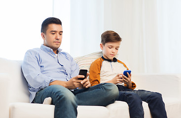 Image showing father and son with smartphones at home