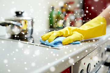 Image showing close up of woman cleaning cooker at home kitchen
