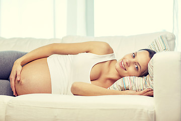 Image showing happy pregnant woman lying on sofa at home