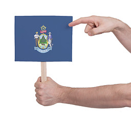 Image showing Hand holding small card - Flag of Maine