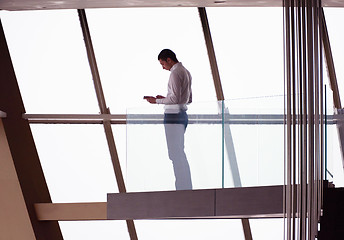 Image showing young successful business man in penthouse apartment working on 