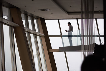 Image showing young successful business man in penthouse apartment working on 