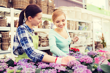 Image showing happy women choosing flowers in greenhouse