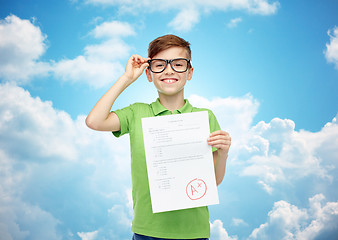 Image showing happy boy in eyeglasses holding school test result