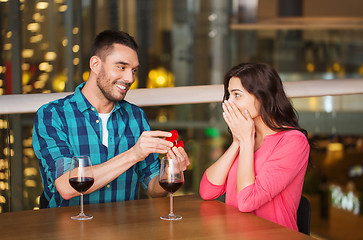 Image showing man giving engagement ring to woman at restaurant