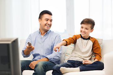 Image showing smiling father and son watching tv at home