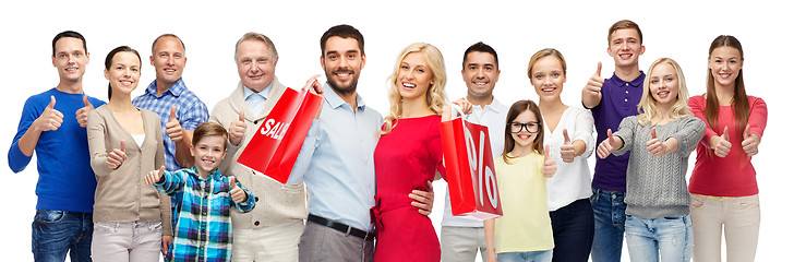 Image showing happy people with shopping bags showing thumbs up