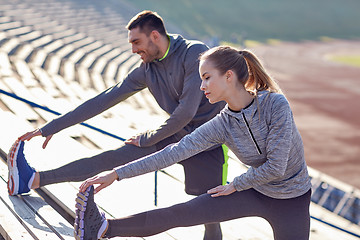 Image showing couple stretching leg on stands of stadium