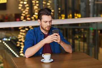 Image showing man with smartphone and coffee at restaurant