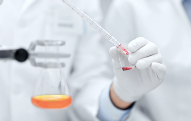Image showing close up of scientists filling test tube in lab
