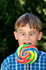 Image showing cross eyed boy eating lollipop