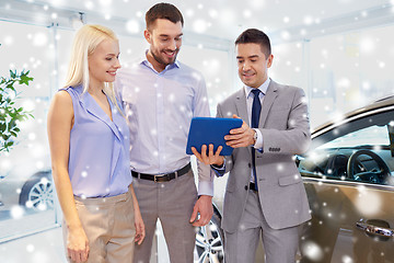 Image showing happy couple with car dealer in auto show or salon