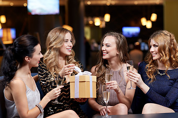 Image showing happy women with champagne and gift at night club